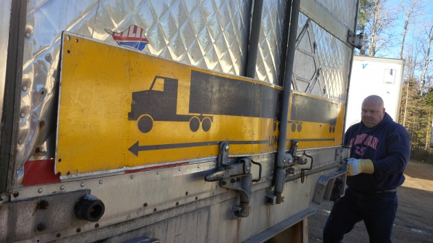 Dwayne Schurman secures the long vehicle sign to the trailing trailer.