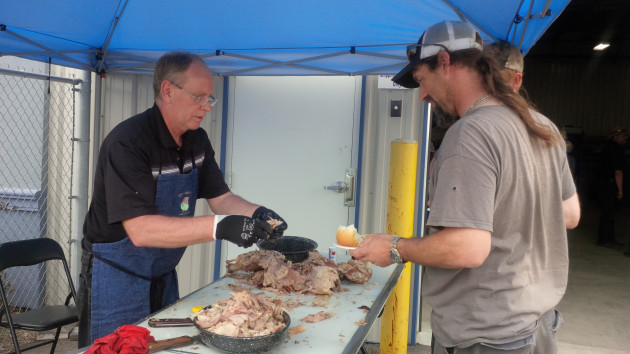 Doug Vandenberg serves a customer at Trison Tarps' third annual pig roast.