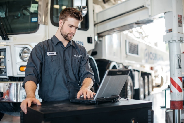 A Mack service technician works to get a truck back on the road.
